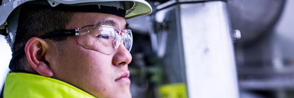 asian oil refinery worker seen in profile